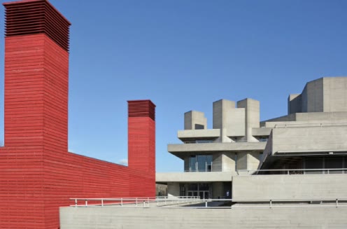Formiture — A red brick stack against a raw concrete facade