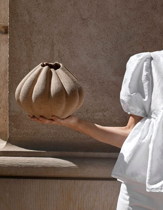 The Clay — A fluted stoneware vessel held in both hands